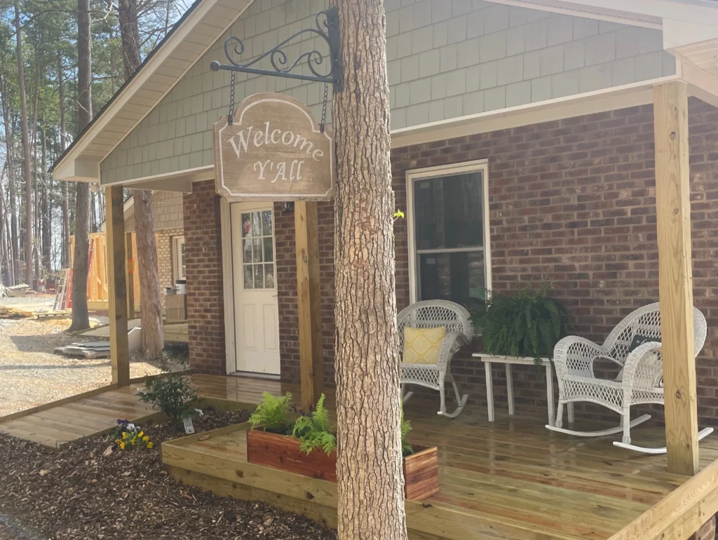 Exterior view of a retreat cabin with front porch and rocking chairs at Wings of Eagles Ranch.